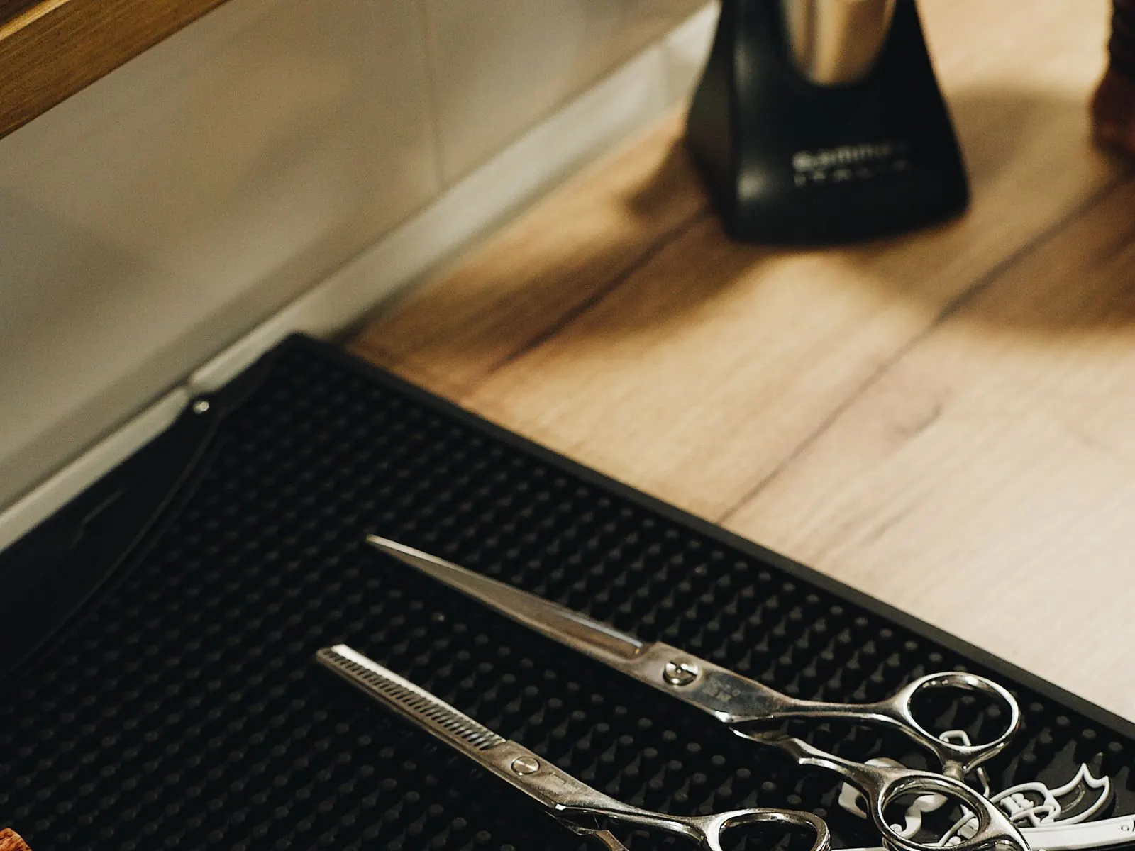 Sfeerbeeld (niet de salon): Kappersscharen op een zwarte mat